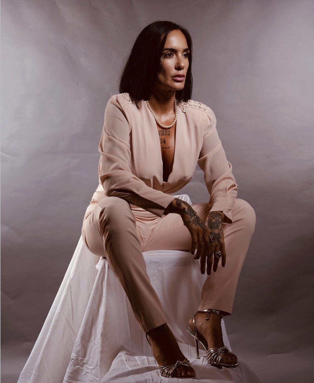 Raffaella Tanzi, creatrice di La Reyna del Cuerpo, seduta in un completo rosa